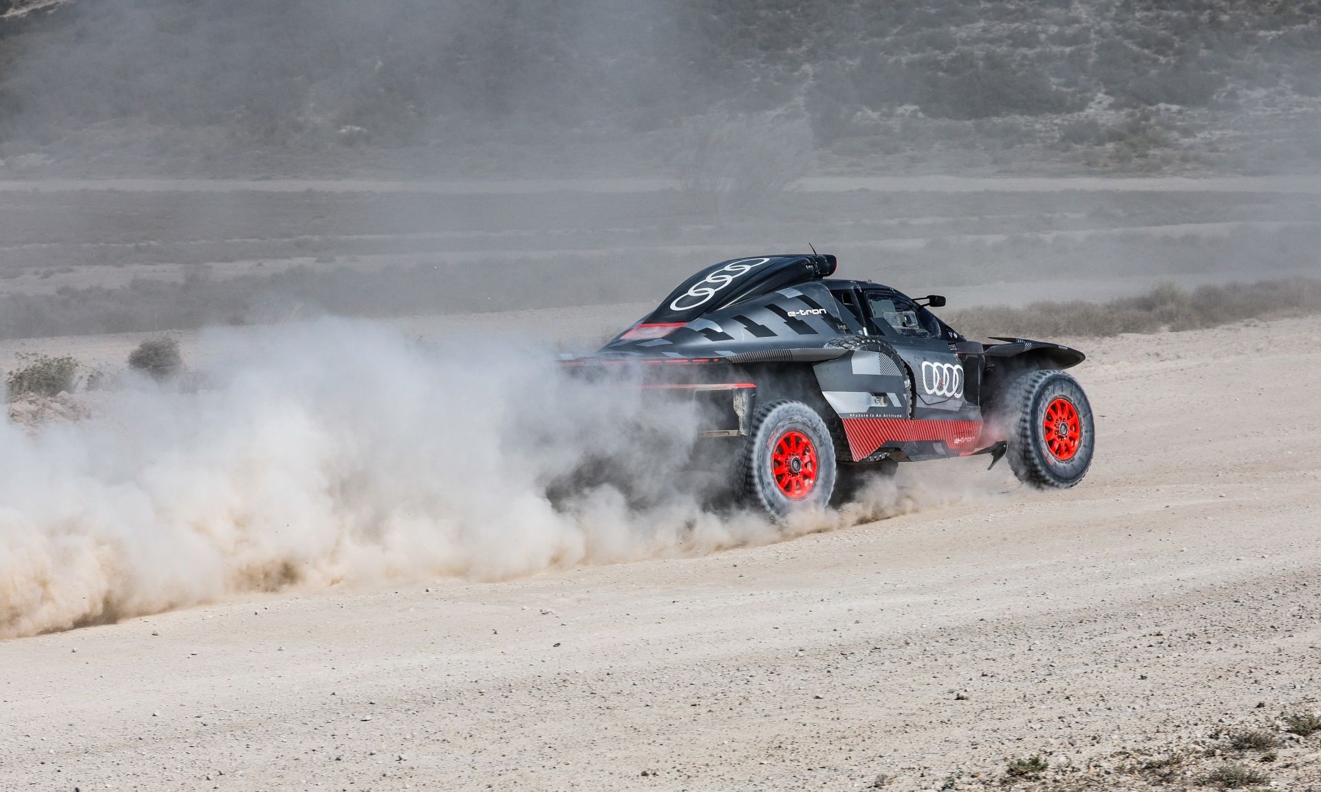 The Audi RS Q e-tron driving on a gravel track.
