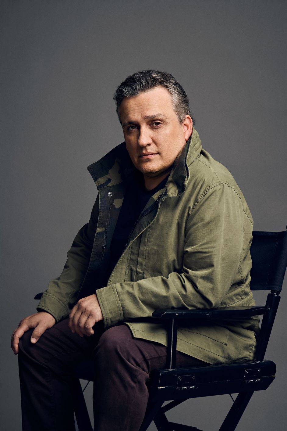 A portrait of Joe Russo sitting in his director’s chair.